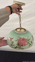 Side view of pendant showing painted floral glass shade and chain