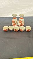 Front view of two sake bottles and five cups