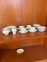 Full set: cups, saucers, plates, sugar and creamer displayed on shelf