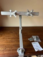 Full view of assembled silver dual monitor arm on desk with base plate attached