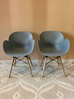 Front view of both grey shell armchairs on rug