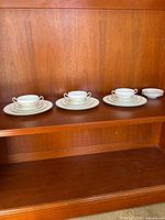Three place settings and extra small plates displayed on shelf