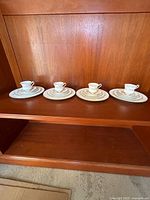 Four identical Paragon Elizabeth Rose place settings lined on shelf