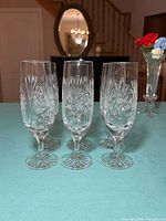 Front view of six pinwheel-cut crystal champagne flutes on table