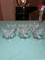 Front angled view of six crystal dessert glasses showing pinwheel cuts and stems