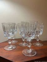 Six cut crystal wine glasses grouped on wooden surface
