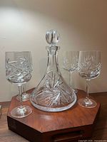 Decanter with stopper centered, four glasses around it