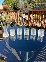 five textured glasses and one conical carafe on table