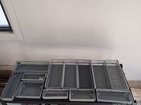 All twelve steel mesh trays arranged side-by-side