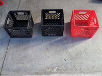 Three crates side by side (two black, one red) showing size and color