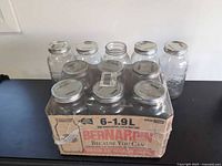Sealed 6-pack of Bernardin jars with five loose jars behind