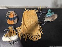 Group shot of four faux suede pouches