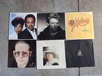 All six album covers and black sleeve laid out on floor