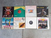 Eight LP records laid out, showing all front covers and plain sleeve.