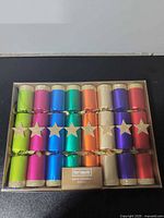 Front view of sealed box showing all 18 multicolor crackers