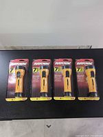 Four sealed Rayovac NR2C flashlights on table