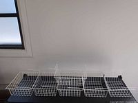 all six white wire under-shelf baskets lined on table