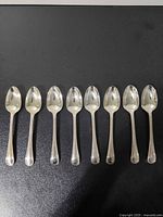 All eight matching sterling silver teaspoons aligned bowl up
