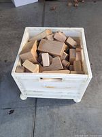 Wooden blocks inside white crate, top angled view