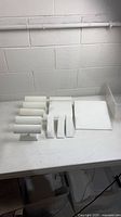 Overview of all white jewelry display stands on table
