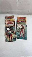 Seven Marvel comic books arranged on table showing covers of Major X and Despicable Deadpool