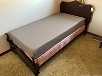Full view of assembled bed with mattress and box spring on frame