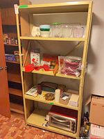 Full view of beige metal shelving unit with four shelves