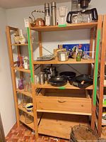 Full view of both pine shelving units loaded with household items
