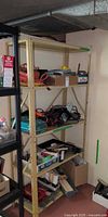 Full view of beige metal shelving unit with four shelves