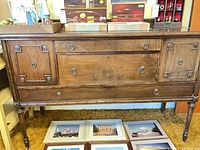 Full frontal view of sideboard showing overall design, finish, hardware, and legs