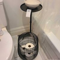 Basket with toilet rolls inside next to toilet and tub