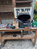 Overview of Big Green Egg grill on table with accessories spread out