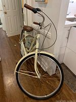 Front view of cream Electra Amsterdam bicycle with basket