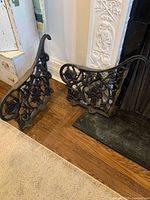 Both cast iron desk legs leaning against fireplace