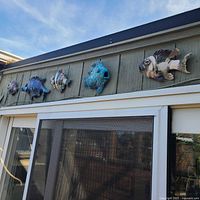 Five ceramic raku fish plaques mounted on exterior wall