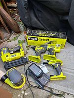 All Ryobi cordless tools, battery and charger laid out together