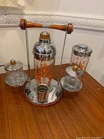 Full view of stand, shaker, two condiment jars, jigger, tall jar