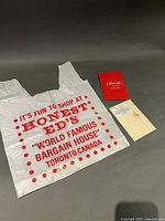 Plastic Honest Ed's shopping bag, pop-up card closed, envelope in sleeve
