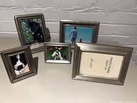 Front view of five pewter frames with sample photos