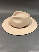 Angled view of beige wool hat showing brim and leather band