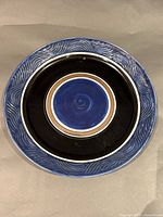 Front view showing blue glaze, concentric rings, textured rim