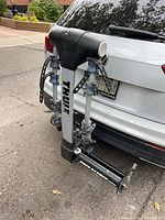 Rack attached to vehicle showing folded arms and hitch fitment
