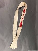 Full view of cream felt sash laid flat