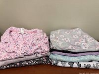 Two folded stacks showing all eight sleepwear pieces