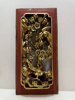 Front view of gilt wood panel showing carved birds and blossoms
