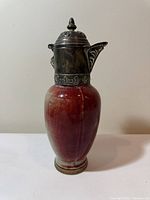 Full view of ewer showing oxblood glaze and metal lid, spout, neck band