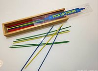 Box opened showing multicolored wooden sticks and interior of sliding lid