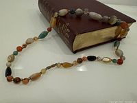 Full view of necklace draped over book showing bead variety and length