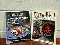 Front covers of both cookbooks displayed upright
