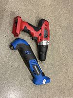 Hyper Tough drill and Mastercraft multi-tool lying on concrete floor